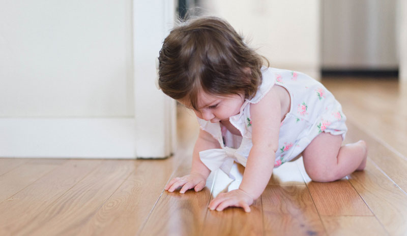 A little girl playing on the floor of her home.