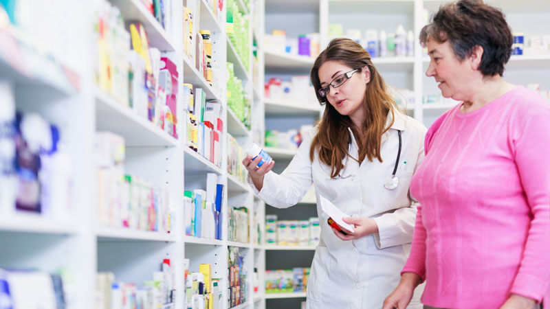 A pharmacist discussing medication with an elderly woman.